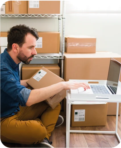 Persona rodeada de cajas frente al computador