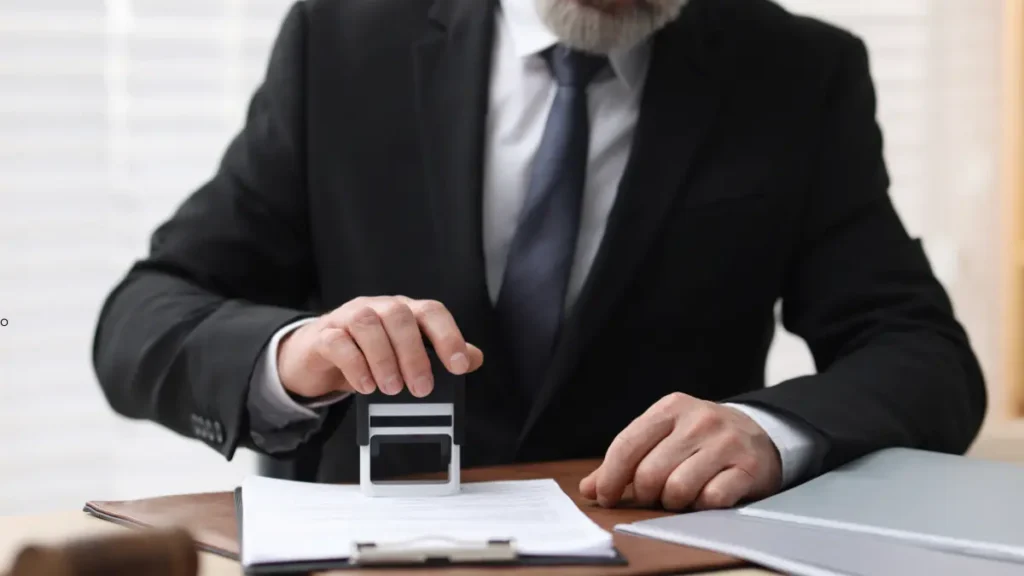 Hombre de traje sellando documentos, parte de la guía para tercerizar trámites notariales y de oficina en Bogotá.